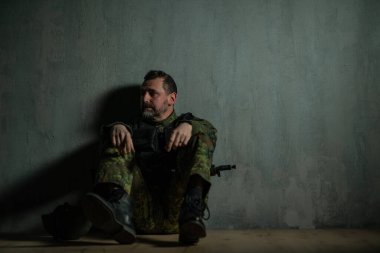 Acemi birliğinde oturan hayal kırıklığına uğramış asker.