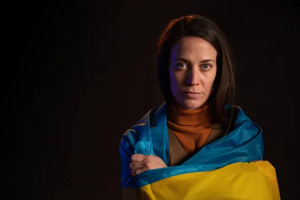 Сумна жінка покрита прапором України. Концепція бути з українським народом у війні з Росією. — стокове фото