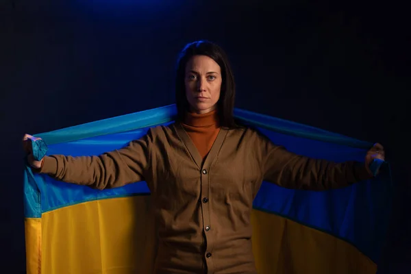 Triste mujer con bandera de Ucrania. Concepto de estar con la nación ucraniana en guerra con Rusia. — Foto de Stock