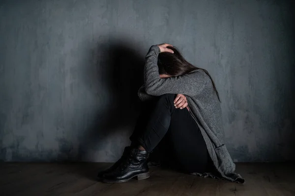 Triste mujer adulta, sola en la oscuridad, sentada y pensando. —  Fotos de Stock