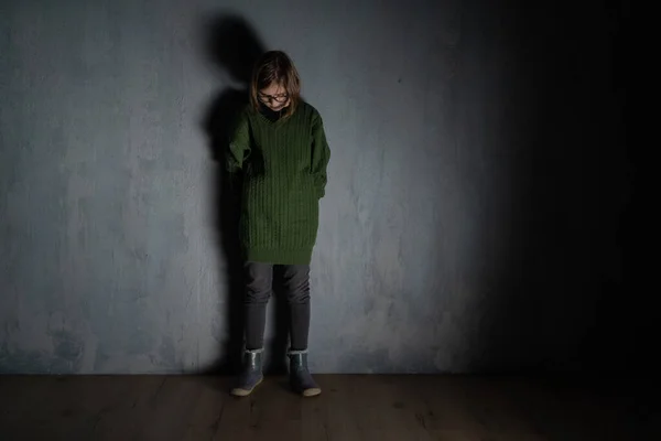 Sad little girl, alone in darkness, standing and thinking. — Stock Photo, Image
