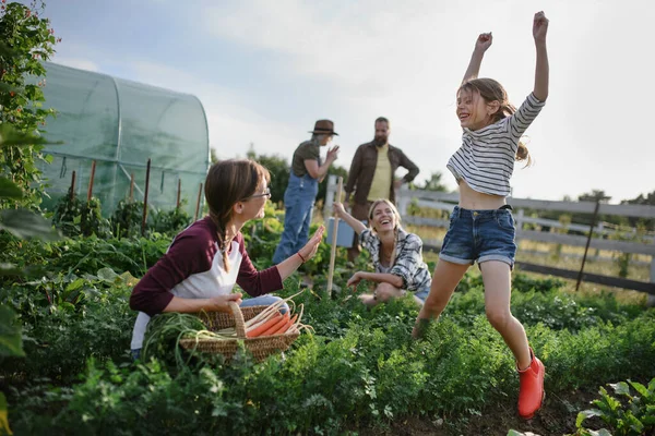 Happy farmers or gardeners working outdoors at community farm. — Stock Photo, Image