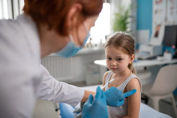 Worried little girl getting vaccinated in doctors office. — Stock Photo, Image