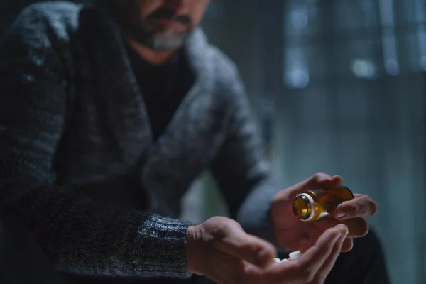 Mature man taking drug pill on dark background, mental health concept. — Stock Photo, Image