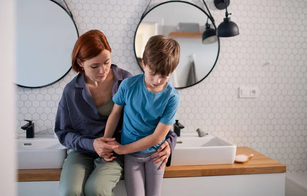 Mère consolant son petit fils bouleversé dans la salle de bain à la maison. — Photo