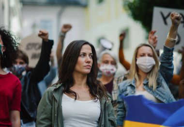 Ukrayna 'daki Rus askeri işgalini protesto eden bir grup aktivist sokakta yürüyor..