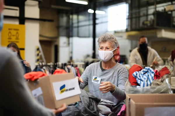 Voluntarios recogiendo donaciones para las necesidades de los migrantes ucranianos, concepto de ayuda humanitaria. — Foto de Stock