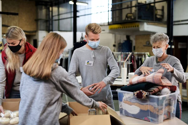 Freiwillige sortieren gespendete Lebensmittel und Kleidung für die Bedürfnisse ukrainischer Migranten, Konzept der humanitären Hilfe. — Stockfoto