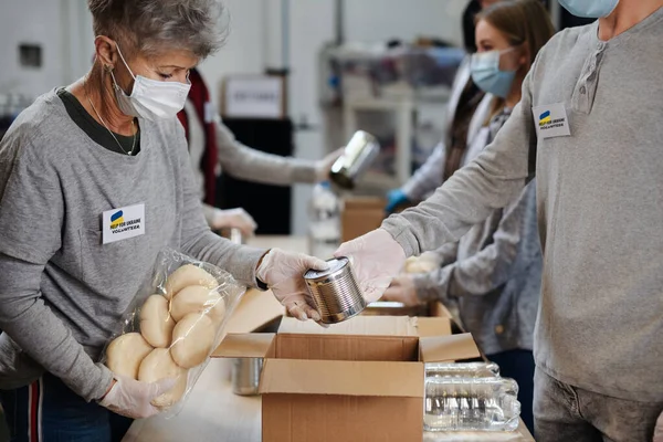 Grupo de voluntarios recogen donaciones para refugiados ucranianos, concepto de ayuda humanitaria. — Foto de Stock