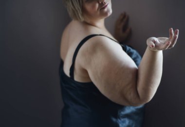 Evde iç çamaşırlı üzgün şişman kadın.