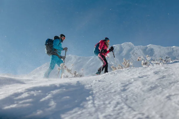 Niski kąt widzenia na narty zwiedzanie para piesze wycieczki w górach. — Zdjęcie stockowe