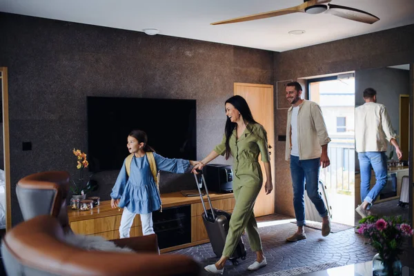Jovem família feliz com duas crianças que penetram quarto no hotel de luxo, férias de verão. — Fotografia de Stock