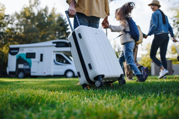 Vista trasera de la familia joven con maletas que van a la caravana al aire libre en el parque. — Foto de Stock
