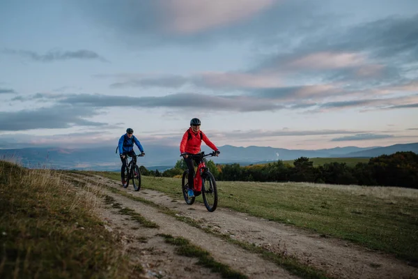 Pareja mayor activa que monta bicicletas al aire libre en la naturaleza en el día de otoño. — Foto de Stock