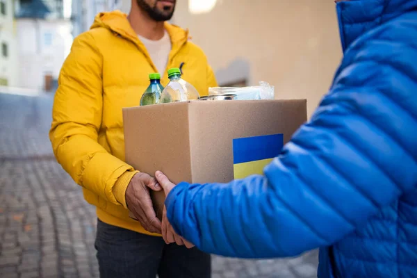 Recorte de voluntarios recogiendo cajas con ayuda humanitaria para refugiados ucranianos en la calle — Foto de Stock