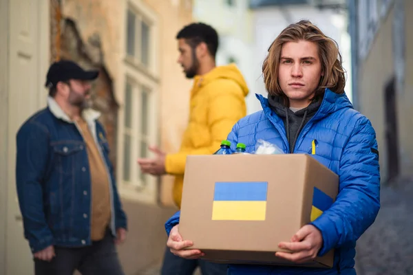 Team of volunteers collecting boxes with Humanitarian aid for Ukrainian immigrants in street — Stock Photo, Image