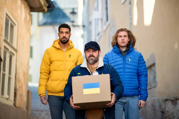 Une équipe de bénévoles collecte des boîtes avec de l'aide humanitaire pour les immigrants ukrainiens dans la rue — Photo