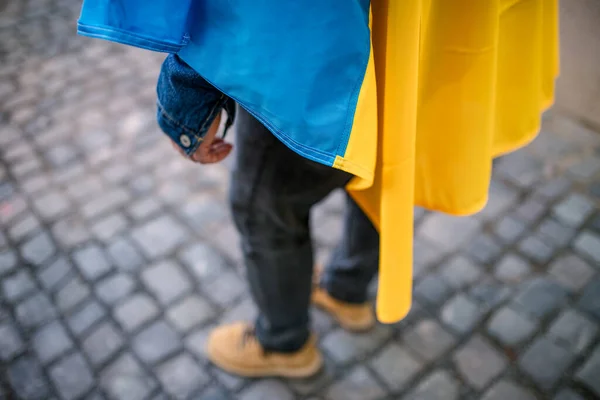 Lowsection de protestante cubierto con bandera ucraniana azul y amarilla protestando contra la guerra en Ucrania en la calle — Foto de Stock