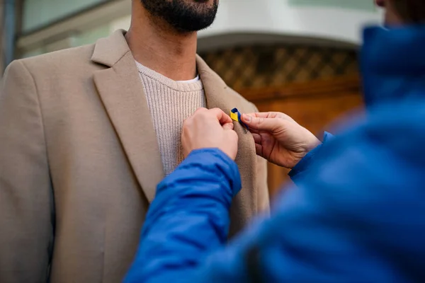 Protestorganisator verspreidt Oekraïense blauwe en gele linten aan mensen die protesteren tegen de oorlog in Oekraïne — Stockfoto