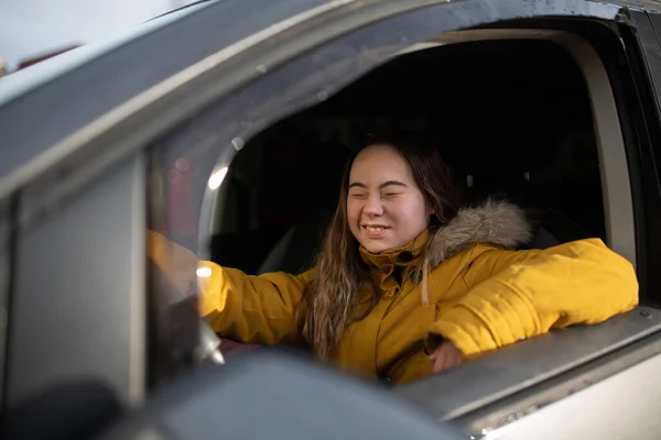 Junge Frau mit Down-Syndrom fährt Auto und lächelt. — Stockfoto