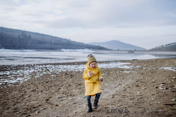 Gelukkige kleine jongen met Down loopt buiten door het meer in de winter. — Stockfoto