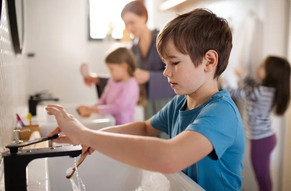 Mother with three little children in bathroom, morning routine concept. — Stock Photo, Image