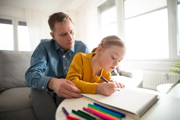 Padre con sua figlia con la sindrome di Down che impara a casa. — Foto Stock