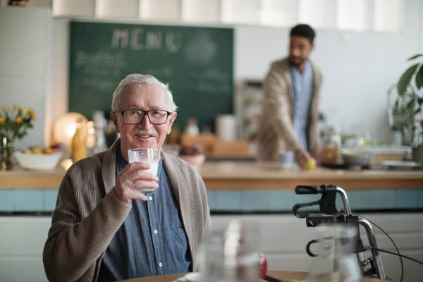 Hombre anciano sonriente disfrutando del desayuno en el centro de atención a hogares de ancianos. — Foto de Stock