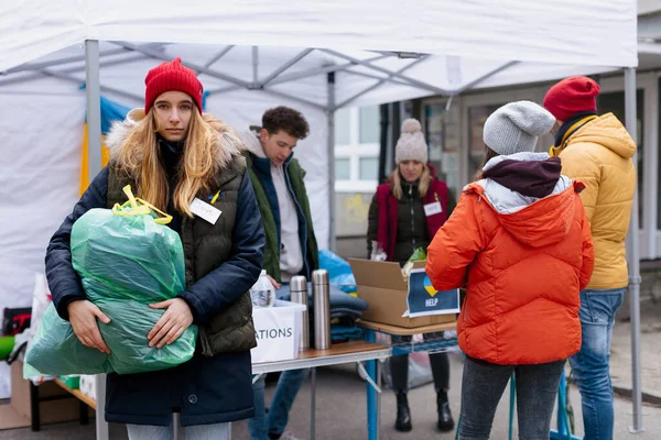 Volontari che distribuiscono donazioni ai rifugiati al confine ucraino, concetto di guerra russo-ucraino. — Foto Stock