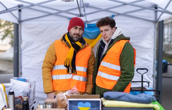 Team di volontari che distribuiscono cibo, bevande e altre donazioni ai rifugiati al confine ucraino. — Foto Stock