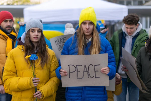 Протест проти вторгнення Росії в Україну. Люди, які тримають анти-воєнні співи та прапори на вулицях.. — стокове фото