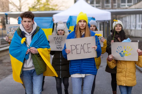 Протест проти вторгнення Росії в Україну. Люди, які тримають анти-воєнні співи та прапори на вулицях.. — стокове фото