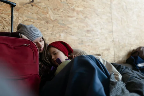 Ukrajinští váleční uprchlíci v dočasném útulku a pomoc centrum, děti unavené a spící. — Stock fotografie