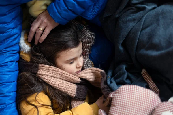 一時的な避難所やヘルプセンターでウクライナの戦争難民,彼女の母親のラップで寝て女の子. — ストック写真
