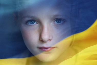 Küçük üzgün mülteci çocuk ve Ukrayna bayrağının iki kez teşhir edilmesi.