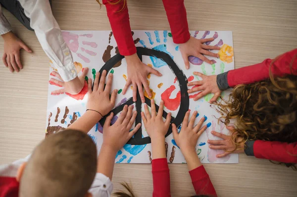 Top view of children making a poster of peace sign at school. — Stock Photo, Image