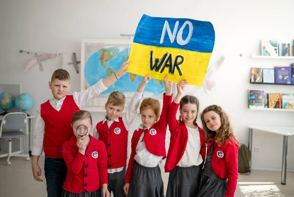 Маленькие школьники празднуют и показывают украинский флаг в классе, без концепции войны. — стоковое фото