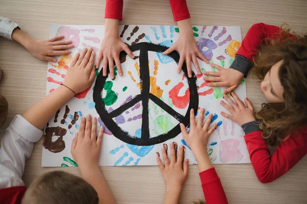 Vista dall'alto dei bambini che fanno un poster di segno di pace a scuola. — Foto Stock
