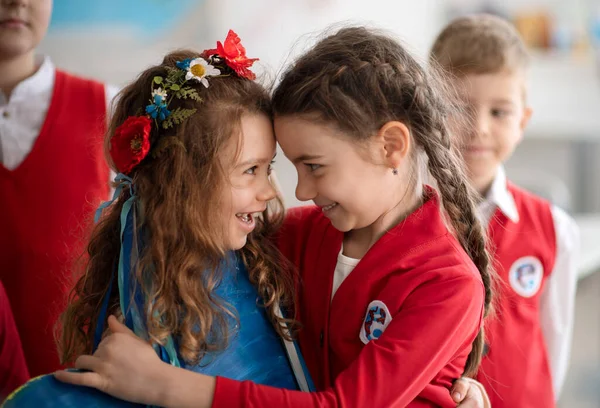 Los escolares dan la bienvenida a un nuevo compañero de clase ucraniano, concepto de inscribir a los niños ucranianos en las escuelas. — Foto de Stock
