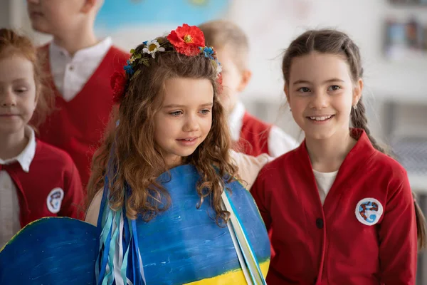 Studenti che accolgono nuovo compagno di classe ucraino, concetto di iscrivere i bambini ucraini alle scuole. — Foto Stock