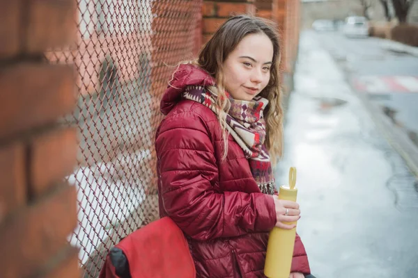 Счастливая молодая женщина с синдромом Дауна зимой отдыхает в городе — стоковое фото