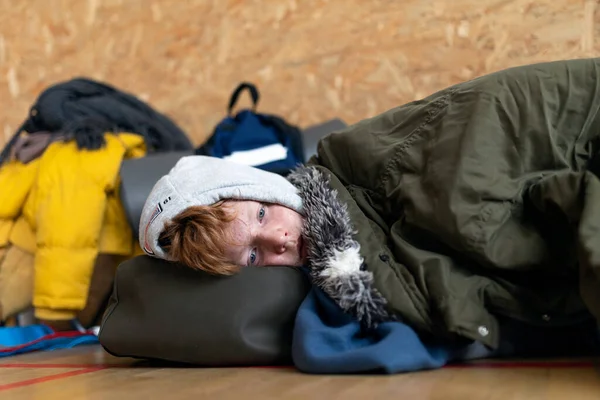 Ukrainian teenage boy war refugee in temporary shelter and help center. — Stock Photo, Image