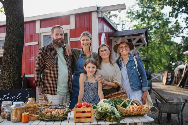 Familia de agricultores que venden productos de cosecha propia en el mercado de agricultores comunitarios, mirando a la cámara. — Foto de Stock