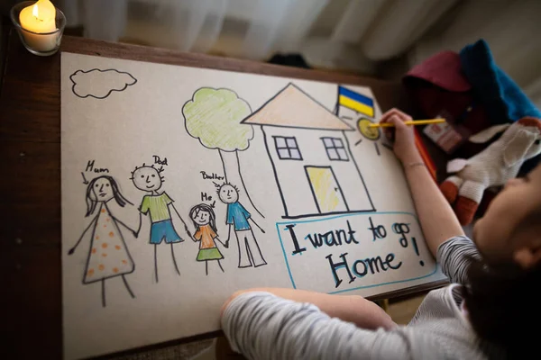 Ukraynalı mülteci kız evlerini özlüyor ve ailesini çiziyor. Ukrayna savaş konsepti. — Stok fotoğraf