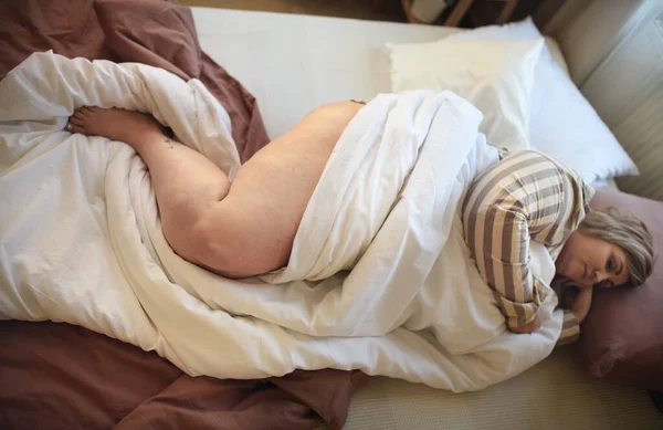 Übergewichtige Frau schläft zu Hause im Bett. — Stockfoto