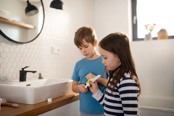 Kleine broers en zussen poetsen tanden in de badkamer, ochtend routine concept. — Stockfoto