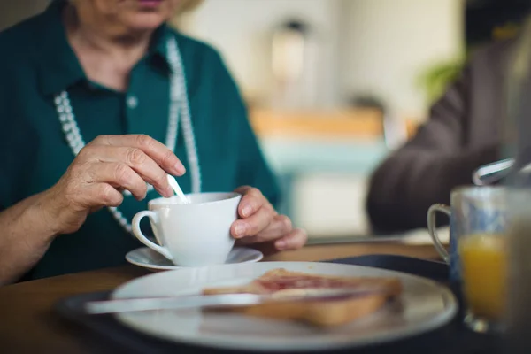 Close-up de mulher idosa desfrutando de café da manhã no centro de cuidados domiciliares. — Fotografia de Stock