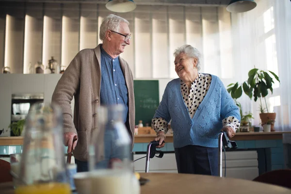 Ηλικιωμένοι άνδρες και γυναίκες περπατούν με τον Γουόκερ σε εσωτερικούς χώρους στη συνταξιοδότηση νοσηλευτική hme. — Φωτογραφία Αρχείου