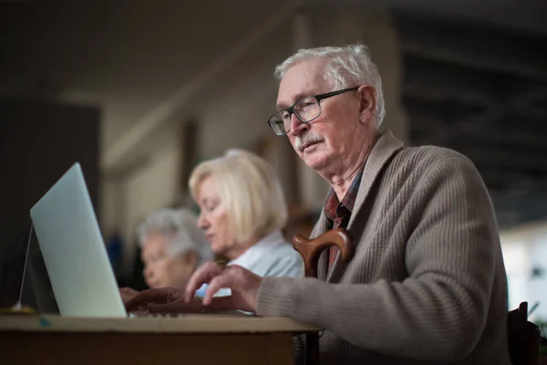 Grupo de personas mayores en el hogar de jubilados aprendiendo juntos en clase de informática —  Fotos de Stock