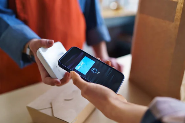 Primer plano del camarero que toma el pago sin contacto del teléfono inteligente del cliente en el restaurante para llevar. — Foto de Stock